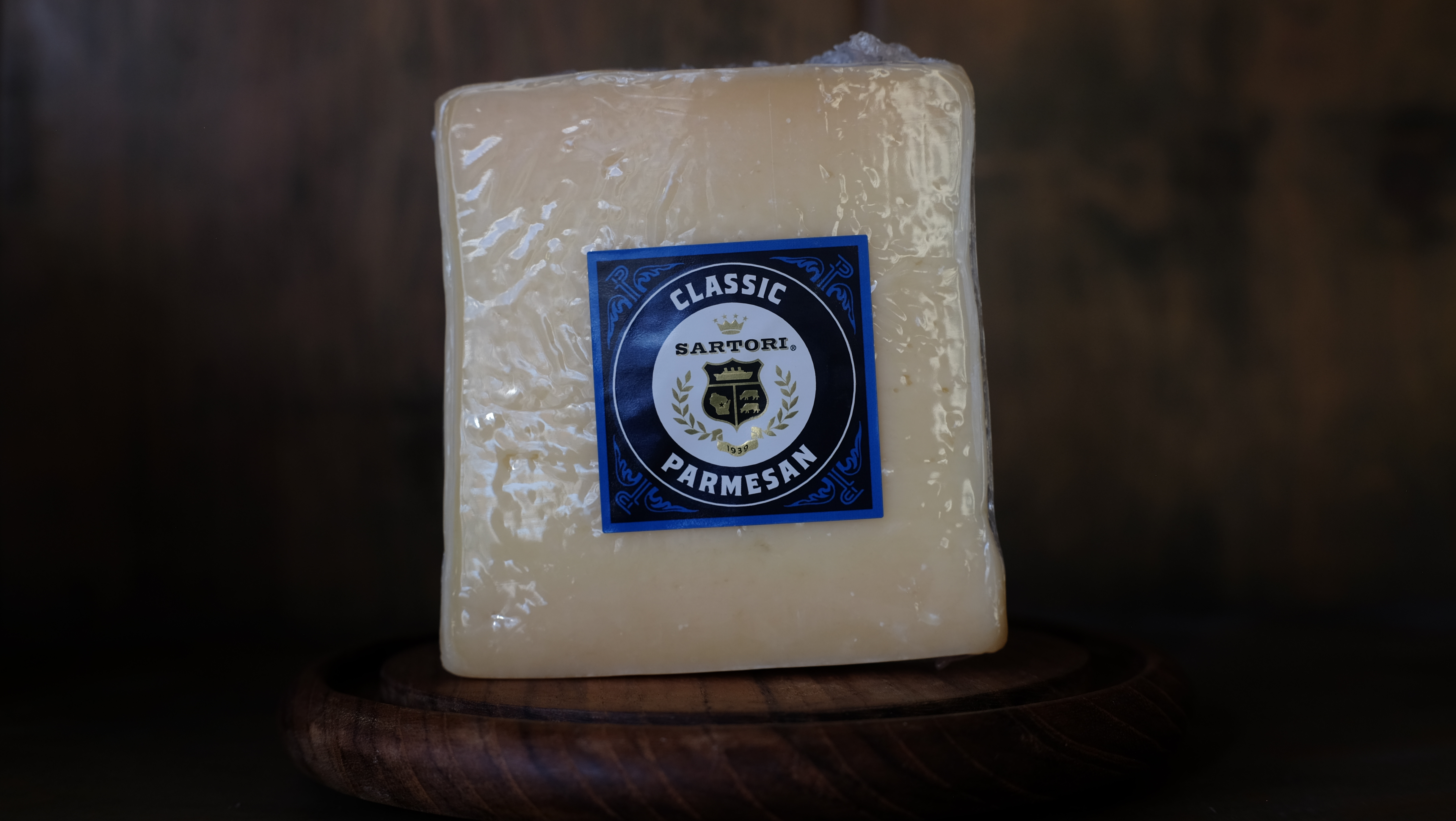 Wedge of Sartori Parmesan cheese on a wooden board
